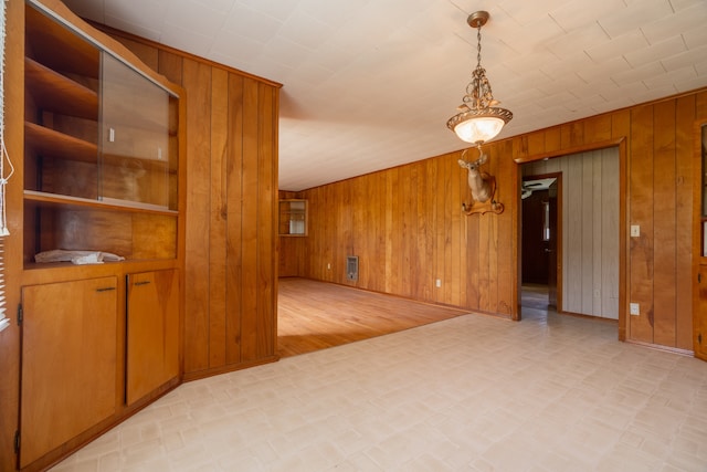 interior space with light hardwood / wood-style floors and wooden walls