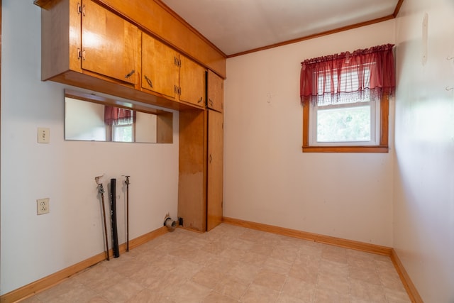 laundry room featuring ornamental molding, washer hookup, cabinets, and light tile floors