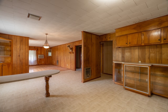 kitchen with decorative light fixtures, wooden walls, and an AC wall unit