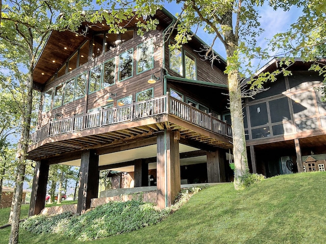 back of house featuring a wooden deck and a yard