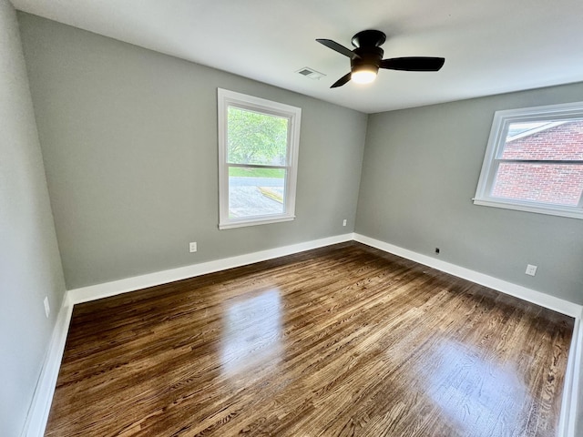 unfurnished room with dark hardwood / wood-style flooring and ceiling fan