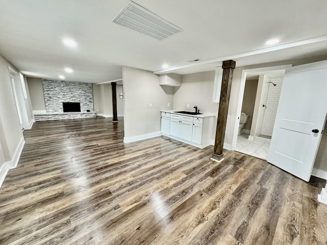 unfurnished living room with a fireplace, dark hardwood / wood-style floors, and sink