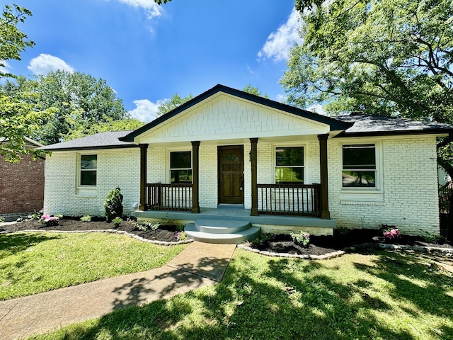 view of front of house with covered porch and a front lawn