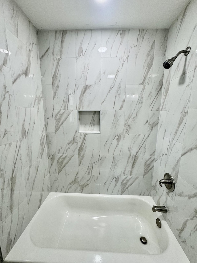 bathroom featuring tiled shower / bath