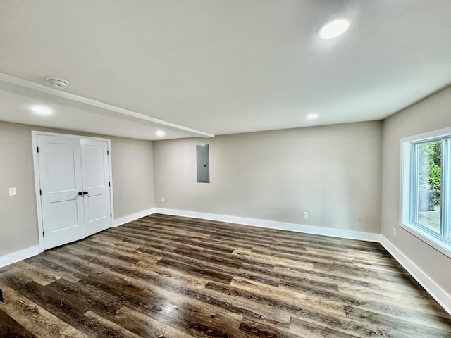 basement with electric panel and dark wood-type flooring