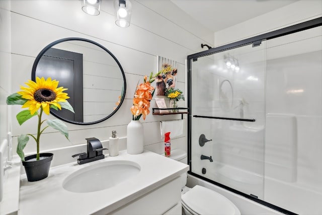 full bathroom featuring vanity, toilet, and enclosed tub / shower combo