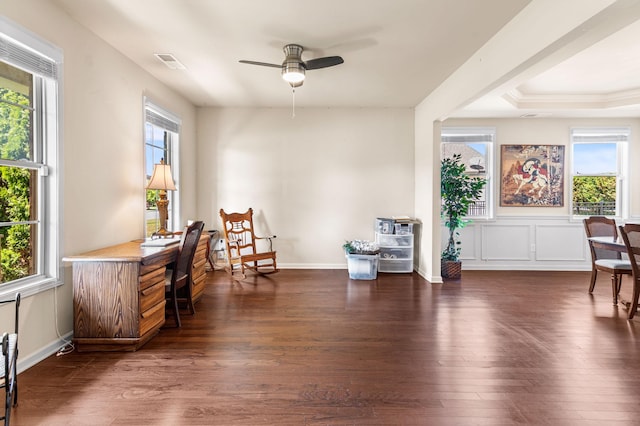 living area with dark wood-style floors, visible vents, a decorative wall, a ceiling fan, and baseboards