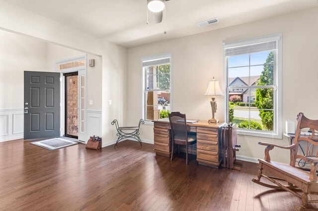 home office featuring a wealth of natural light, wood-type flooring, visible vents, and a decorative wall