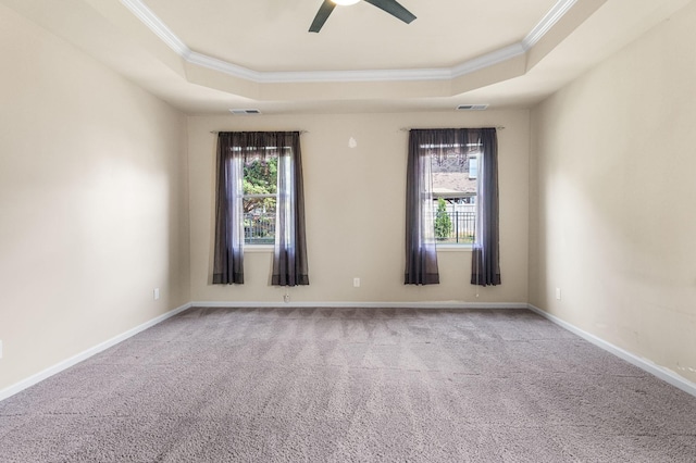 unfurnished room with a raised ceiling, visible vents, and crown molding