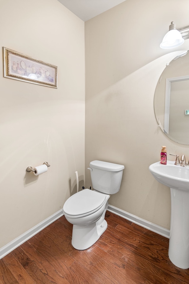 bathroom with toilet and hardwood / wood-style floors