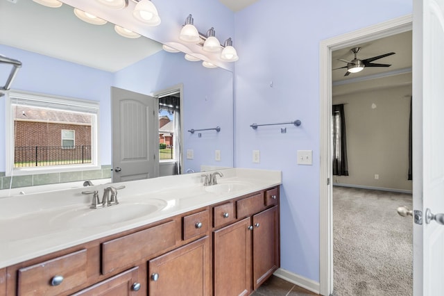 full bath with a ceiling fan, a sink, baseboards, and double vanity