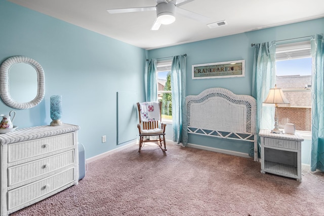 living area featuring baseboards, visible vents, ceiling fan, and carpet flooring