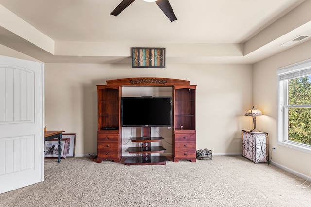 interior space featuring ceiling fan, a tray ceiling, and carpet