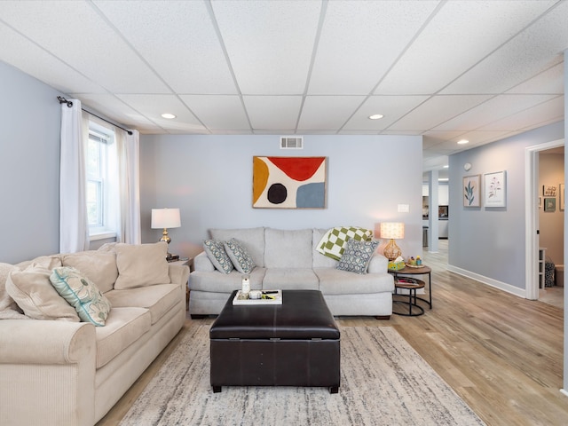 living room with a paneled ceiling and wood-type flooring