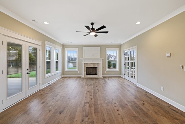 unfurnished living room featuring french doors, a fireplace, ornamental molding, wood-type flooring, and ceiling fan