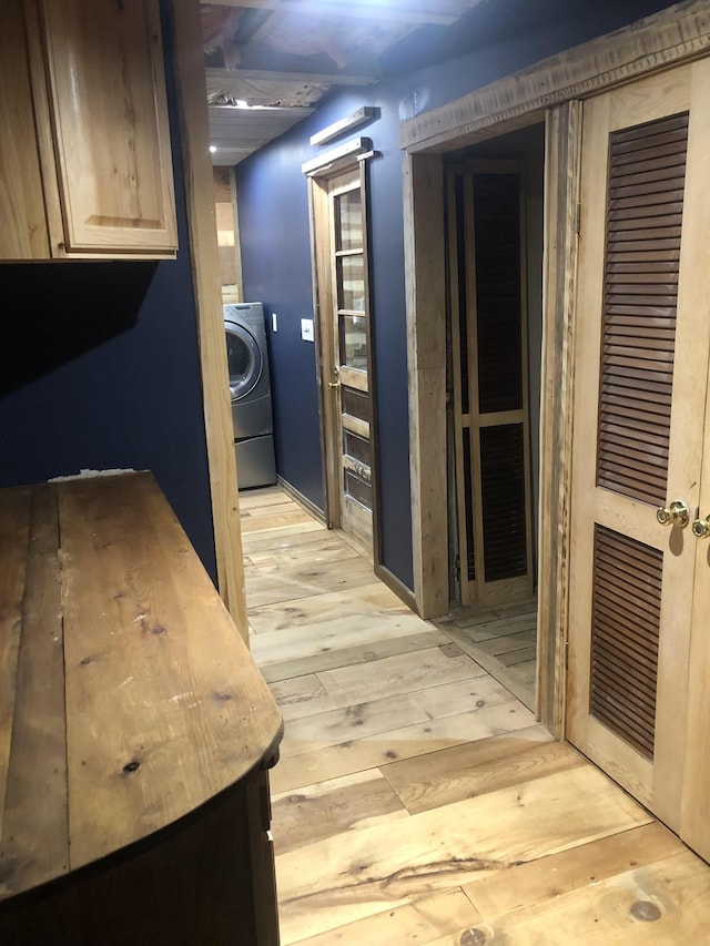 corridor with washer / clothes dryer and light hardwood / wood-style flooring