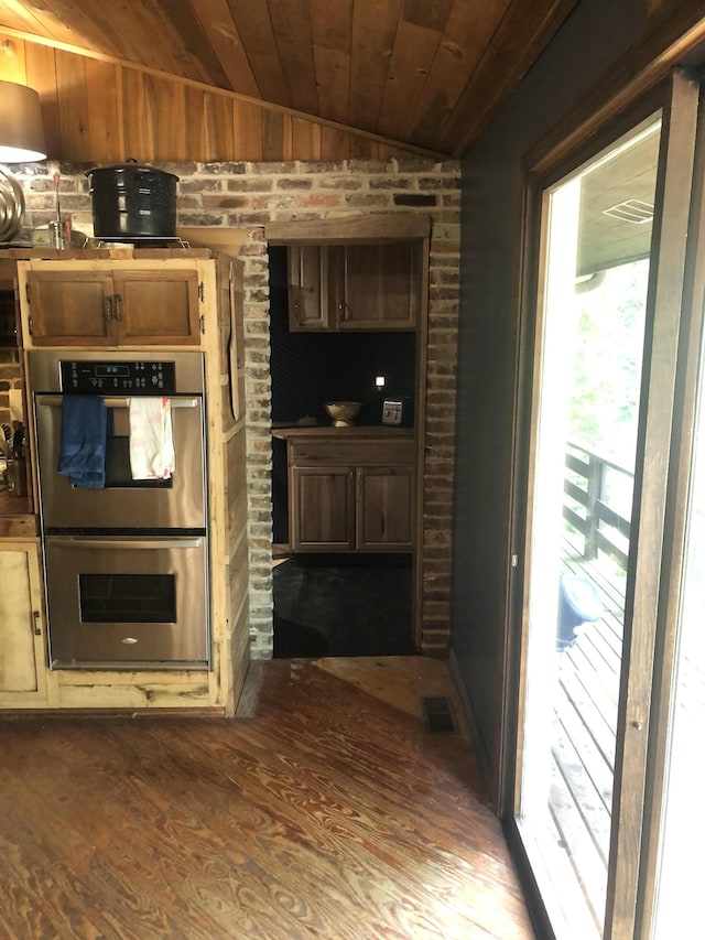 kitchen featuring stainless steel double oven, vaulted ceiling, dark wood-type flooring, and wood ceiling