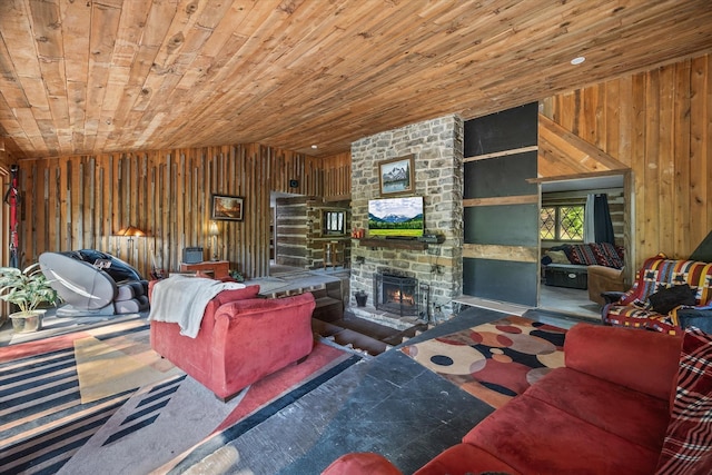 carpeted living room with lofted ceiling, wood walls, a stone fireplace, and wooden ceiling