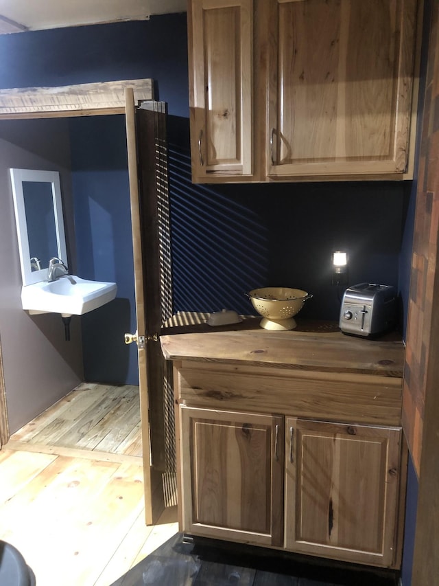 kitchen with butcher block counters, sink, and dark wood-type flooring