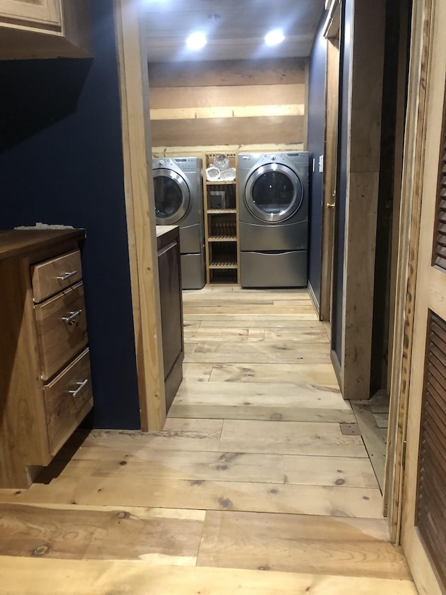 washroom featuring washer and clothes dryer and light hardwood / wood-style flooring