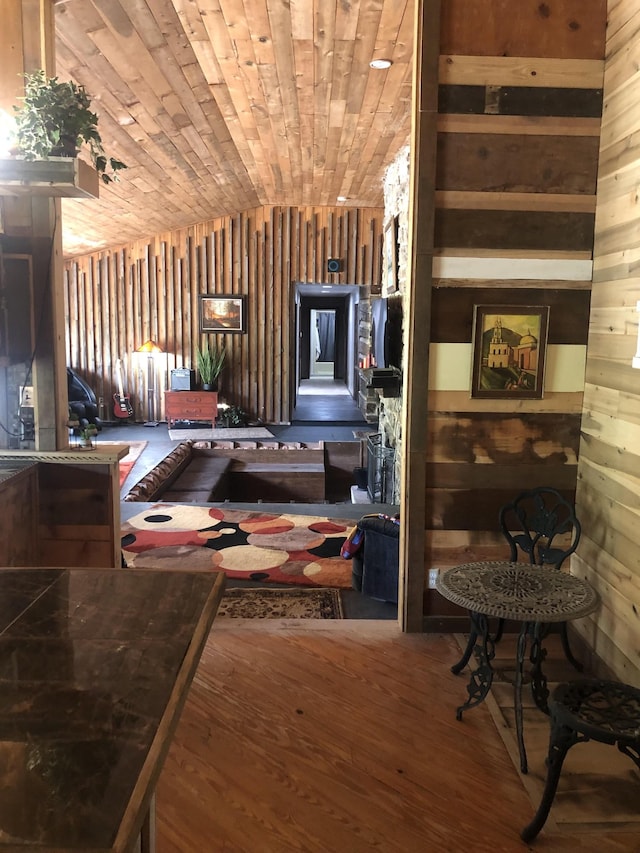 miscellaneous room featuring wood walls, wood-type flooring, and vaulted ceiling