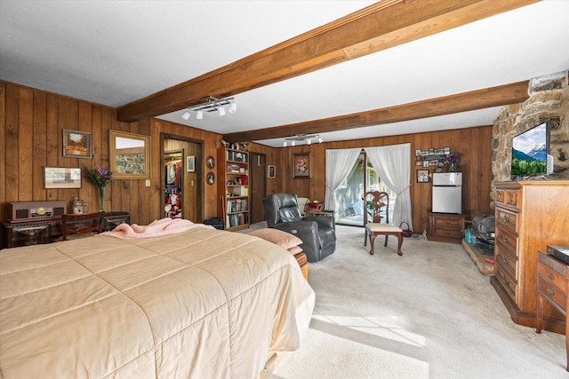 carpeted bedroom featuring beam ceiling, white fridge, and wood walls