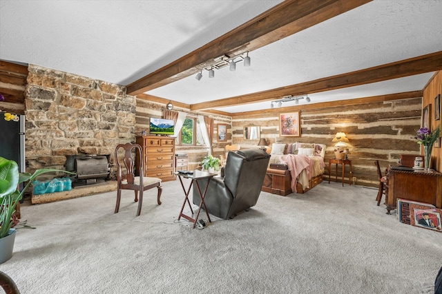 bedroom with carpet flooring, wooden walls, beamed ceiling, and a textured ceiling