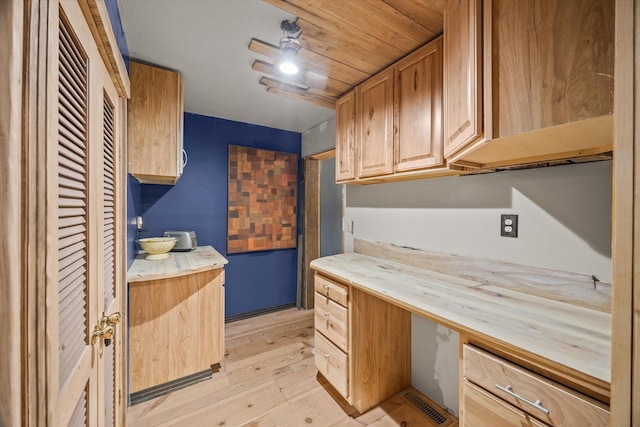 kitchen featuring wood ceiling, built in desk, and light wood-type flooring