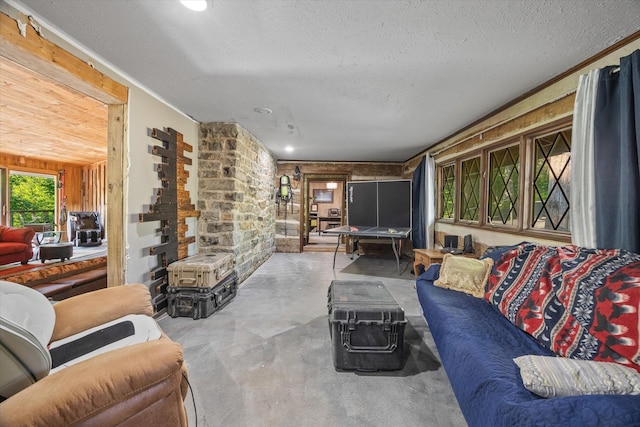 living room with wooden walls and a textured ceiling