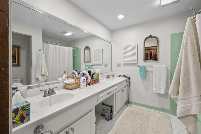 bathroom with curtained shower, tile patterned flooring, vanity, and toilet