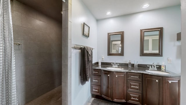 bathroom featuring a tile shower and vanity