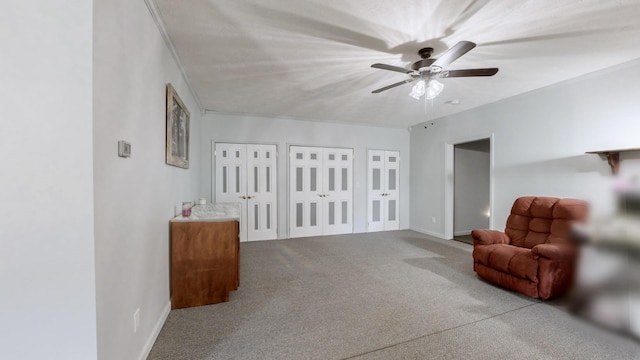 living area featuring ceiling fan and carpet