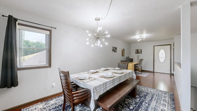 dining space featuring dark wood-type flooring and a chandelier