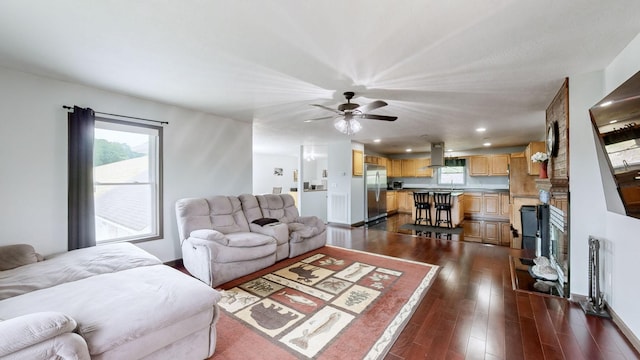 living room with ceiling fan and dark hardwood / wood-style flooring