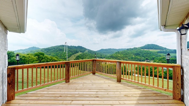 deck featuring a mountain view and a yard