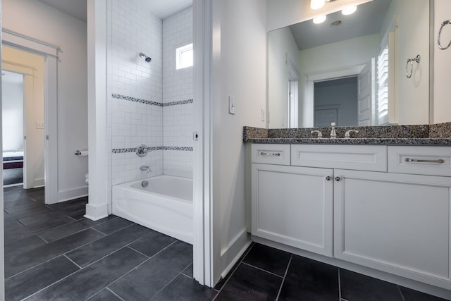 bathroom with tile flooring, vanity, and tiled shower / bath combo