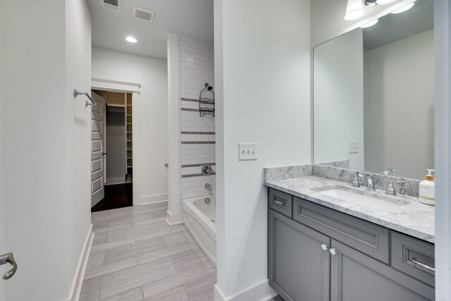 bathroom featuring tile flooring, oversized vanity, and tiled shower / bath combo