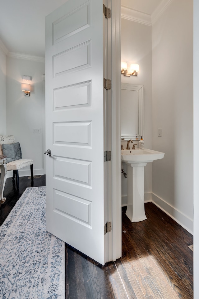 bathroom featuring ornamental molding, hardwood / wood-style floors, and sink