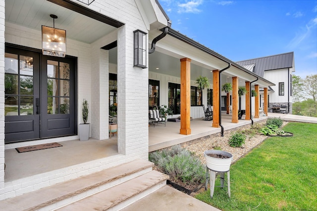 property entrance with a lawn, french doors, and a porch