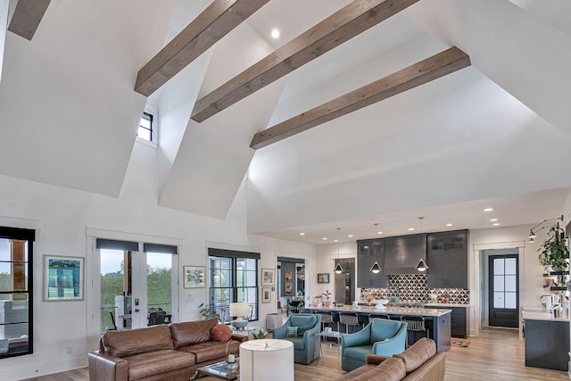 living room with beamed ceiling, high vaulted ceiling, and light hardwood / wood-style floors