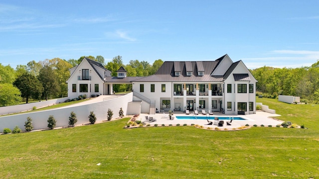 rear view of house featuring a yard, a patio area, and a balcony