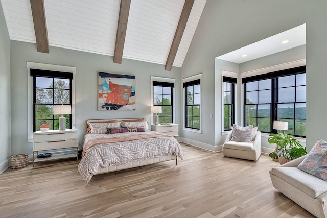 bedroom with beam ceiling, high vaulted ceiling, multiple windows, and light wood-type flooring