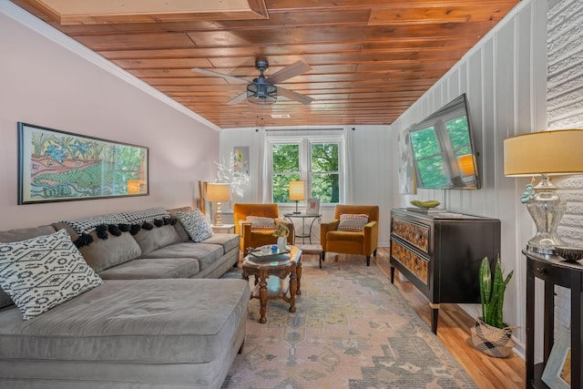 living room with wood walls, crown molding, wood-type flooring, wooden ceiling, and ceiling fan