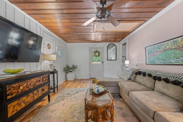 living room featuring wooden walls, ornamental molding, ceiling fan, wooden ceiling, and light wood-type flooring