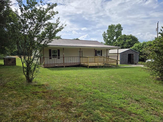 back of house with a deck, a shed, and a lawn