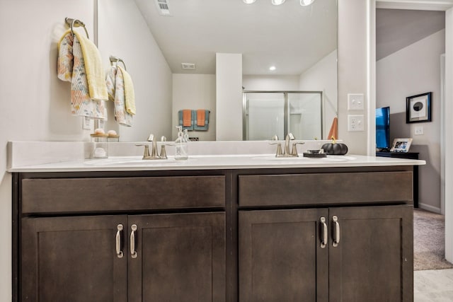 bathroom with vanity and a shower with shower door