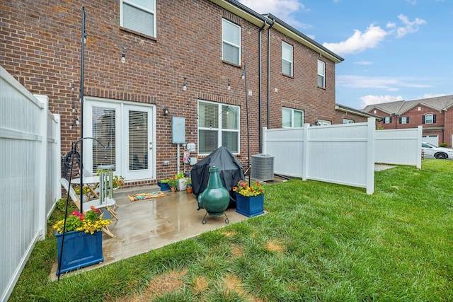 back of house with a lawn and a patio