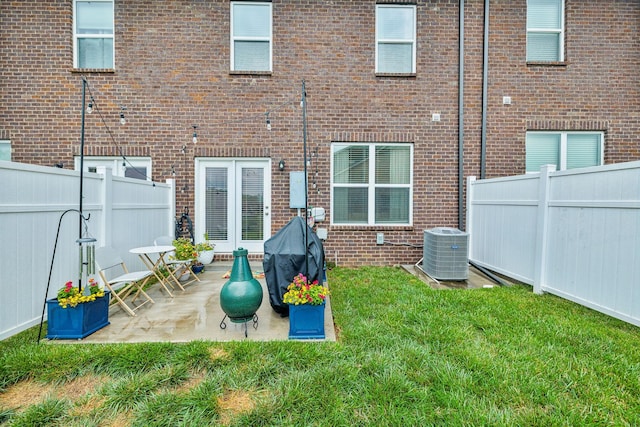 back of property with a patio, a lawn, and central air condition unit