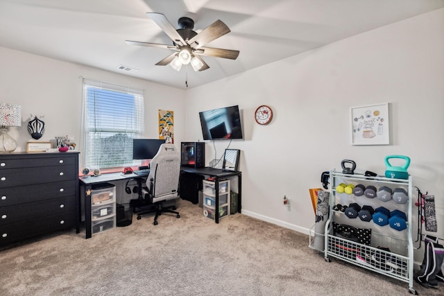 carpeted office space featuring ceiling fan