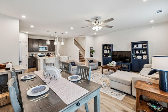 dining space with light wood-type flooring, ceiling fan, and sink